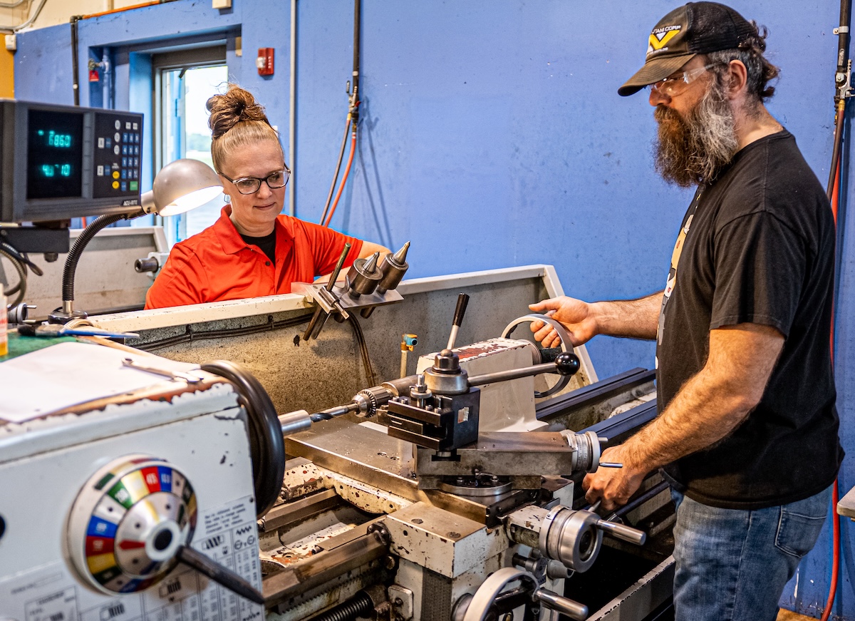 EIT instructor guides student on CNC lathe process